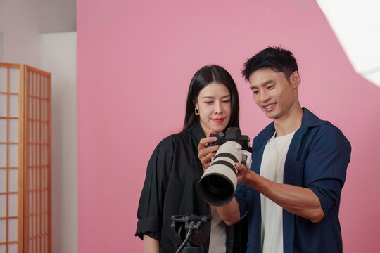Photographer and model reviewing photos on camera in studio