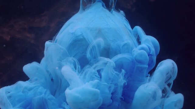 Ink wave. Paint blob water. Blue dye spreading on glass diamond brown sphere. Art fog color blur splash on black background free space.