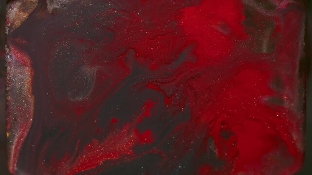 Shimmer paint. Pigment splatter. Defocused red orange purple color sparkling liquid rock glitter particles on abstract background.