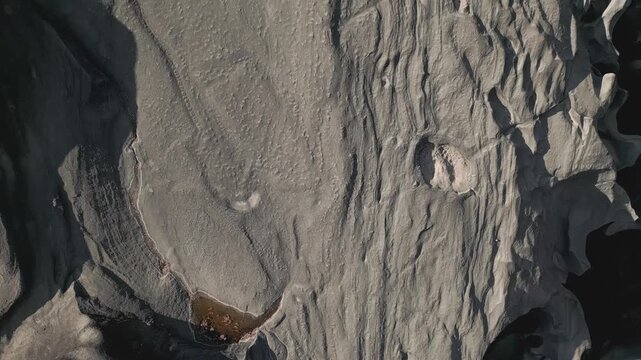 Quartzite bedrock sculpted by the Sao Miguel River forms polished rock pavement and erosional channels at Vale da Lua, Alto Paraiso de Goias, Chapada dos Veadeiros, Brazil, top-down drone ascent