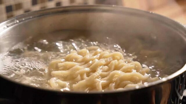 Asian Noodles Boiling in Pot of Hot Water with Rising Steam