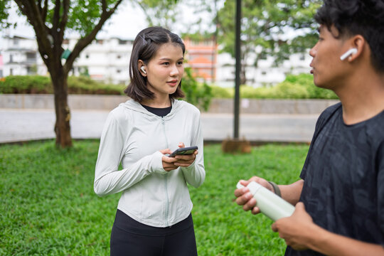 Gen Z Asian woman and African American mixed race man multicultural friends in urban park representing diversity wellness and positive active lifestyle.