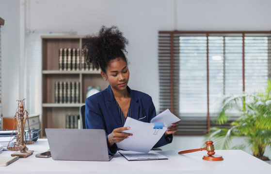 African american woman lawyer reviewing legal documents in office