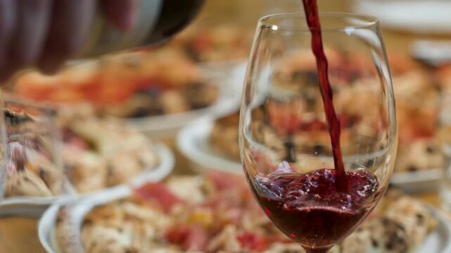 Red Wine Pouring into Glass at Italian Restaurant Table