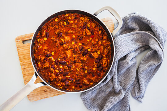homemade vegetarian tempeh kidney bean chilli with corn in cooking pot