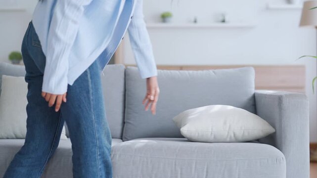 Asian woman resting at home on couch, feeling exhausted after work, lacking energy, or overworked, too tired, and lacking motivation