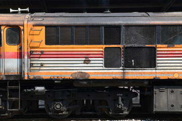 side of colourful diesel locomotive with rusty texture and air horn on roof at train station © andy0man