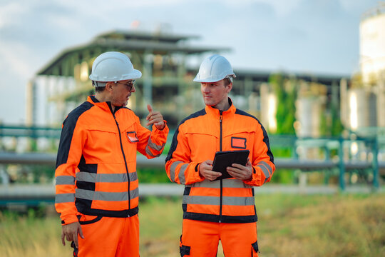 Industrial engineers reviewing engineering drawings before maintenance work petrochemical plant. Technical documentation, project planning, refinery operations, industrial, engineering  