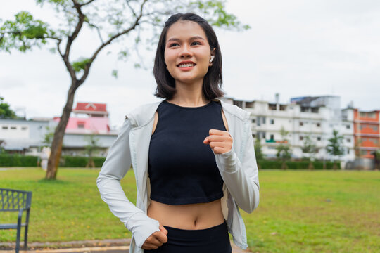 Asian sporty woman running in public park