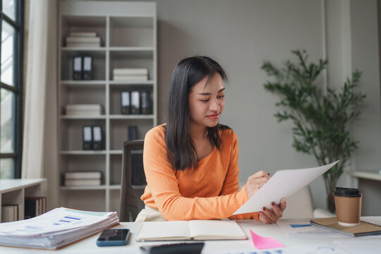 Young woman analyzing reports and managing finances remotely