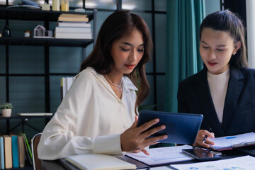 Obraz premium Asian boss businesswoman working with intern together in office room