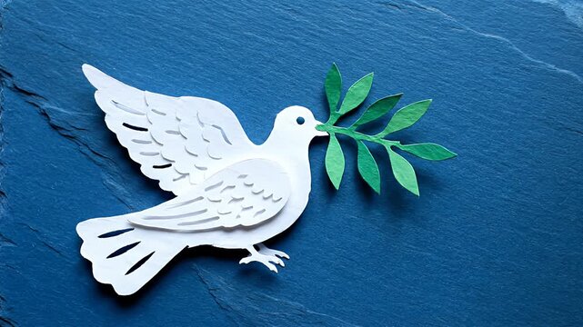 White paper dove with olive branch on blue slate