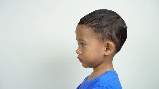 A mother is checking her son's body temperature using a non-contact infrared digital thermometer on his forehead demonstrating health care and medical check-up at home.