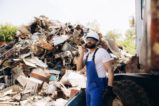 Worker talking on phone at metal scrapyard