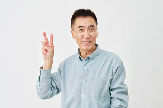 白背景でピースサインの男性