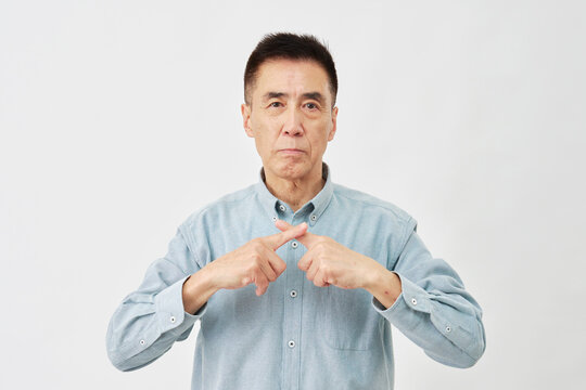 白背景でバツ印のジェスチャーをする男性