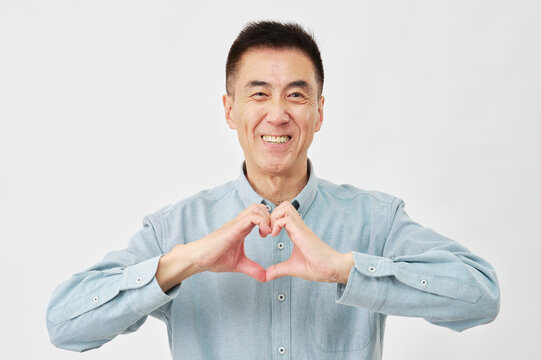白背景でハートのジェスチャーをする男性