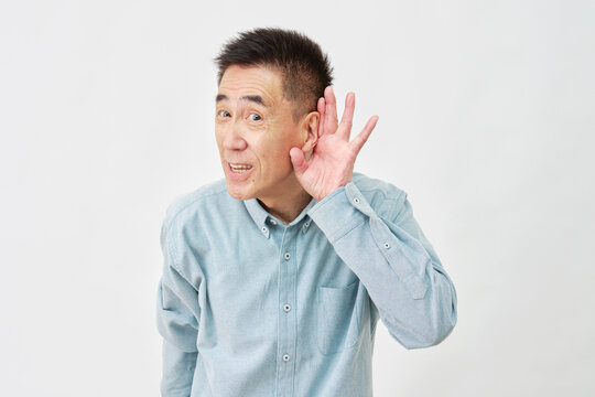 白背景で聞き耳を立てる男性