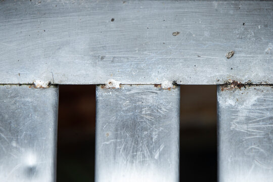 Close up of weathered metal drain grate with scratches and weld joints.A detailed close-up shot of a stainless steel or iron drainage grate texture. 