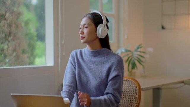 Woman relaxes indoors at home listening music with headphones