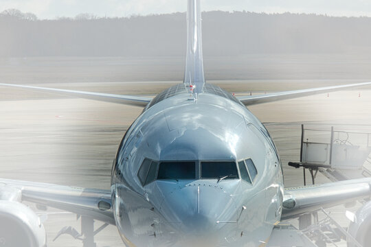 Frontalansicht eines Passagierflugzeugs auf dem Rollfeld durch eine spiegelnde Glasscheibe fotografiert