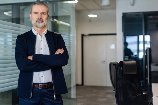 Confident pensive mature business man in modern office.