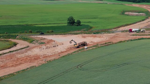 High angle shot of heavy machinery working on the new Szczecin bypass road project in Poland. Suitable for civil engineering, infrastructure development, and industrial progress themes.