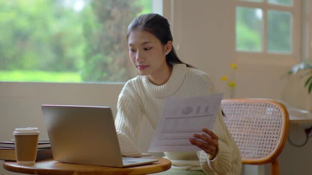 Woman concentrates on laptop work sitting at desk in living room