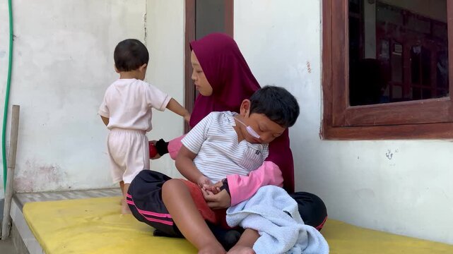 mother supporting a child with a disability and medical nasal feeding tube at home
