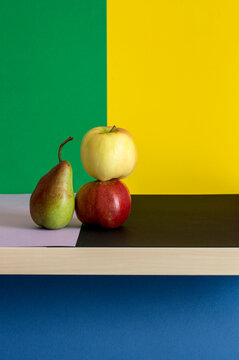 Still life with apples and pears on a colored background