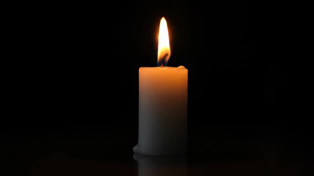 Close-up of a burning white candle, close-up of a lit candle flame