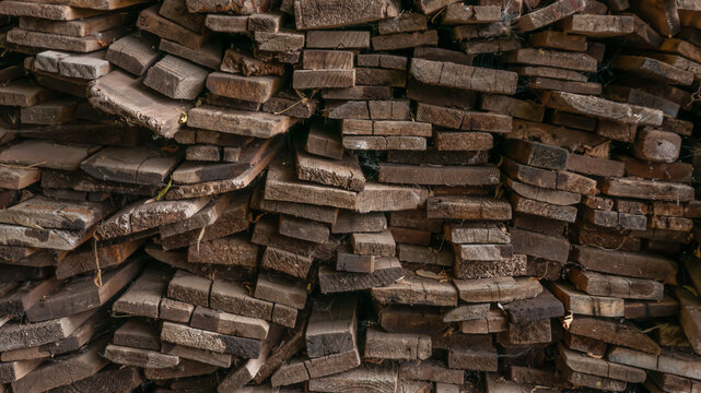 Stack of old weathered wooden boards texture, rough timber pile background