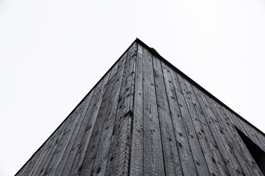 Low-angle view of a building clad in black charred timber using the traditional Shou Sugi Ban (Yakisugi) wood preservation technique, with minimalist architecture and copy space