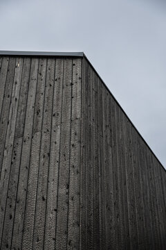 Low-angle view of a building clad in black charred timber using the traditional Shou Sugi Ban (Yakisugi) wood preservation technique, with minimalist architecture and copy space