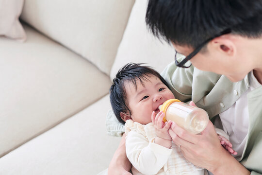 ミルクをあげる父親と赤ちゃん