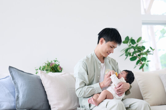 ミルクをあげる父親と赤ちゃん