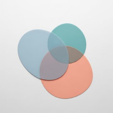 Minimalist composition of three overlapping translucent geometric circles in pastel teal, light blue, and coral peach tones, forming a Venn diagram layout on a plain white background.