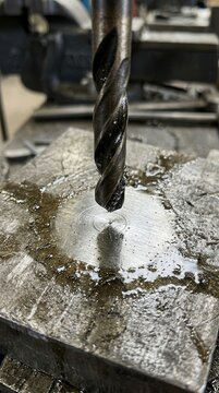 Metal drill bit engaged in a precision machining process