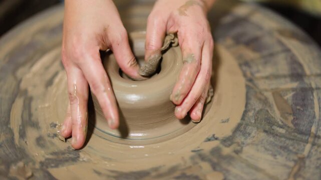 Artisan Hands Shaping Wet Clay on Spinning Pottery Wheel
