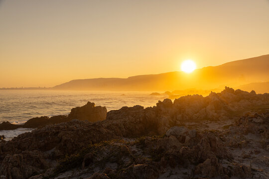 beautiful rugged rocky coastline of Kammabaai Beach, Hermanus, South Africa at sunset and dusk