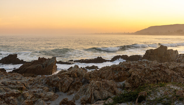 beautiful rugged rocky coastline of Kammabaai Beach, Hermanus, South Africa at sunset and dusk