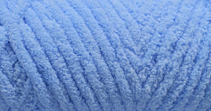 Blue fluffy yarn texture. Close-up soft chenille fabric with braided fluffy surface, smooth motion. Ideal for fashion, cozy and textile backgrounds.