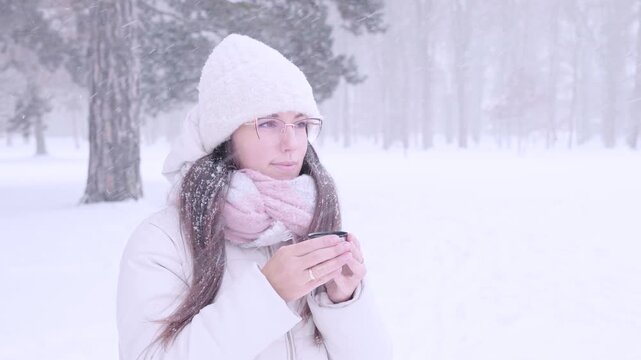 Woman winter tea. Female drinking hot beverage outdoors. Self care concept.