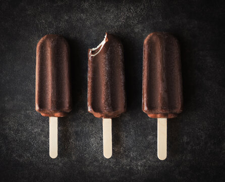 Overhead of three chocolate ice cream bars one with a bite