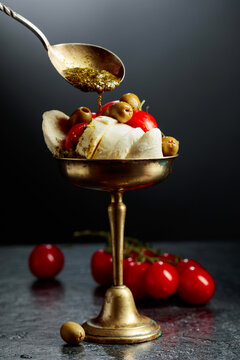 Mozzarella with pesto sauce, green olives, and red cherry tomatoes.