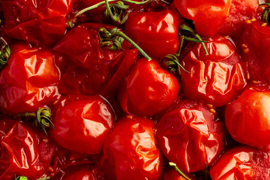 Roasted red cherry tomatoes on a black background.