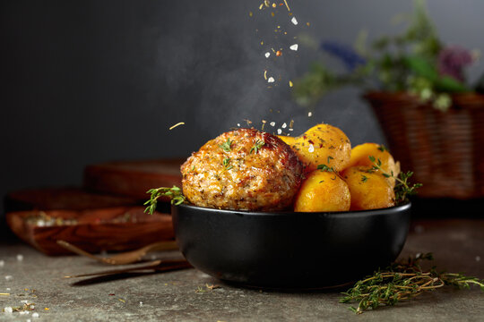 Roasted potatoes with cutlet sprinkled with spices.