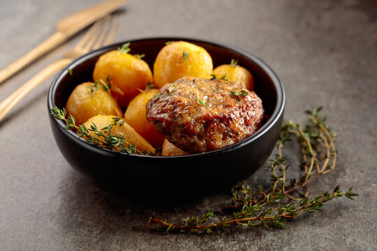 Roasted potatoes with cutlet and thyme.