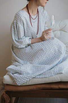 Elegant Woman in Checkered Dress Holding Wine Glass Indoors