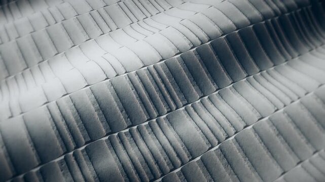 Widescreen loop of finely ribbed light gray material with soft undulating waves, grooved texture background for interior and product design